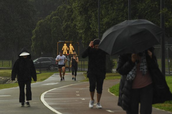 Signs on the Bay Run at Lilyfield remind exercisers to socially distance on Monday.