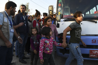 A group of Syrians disembarks from one of the buses that brought hundreds of displaced Syrians to the Bardarash refugee camp in Iraqi Kurdistan. 