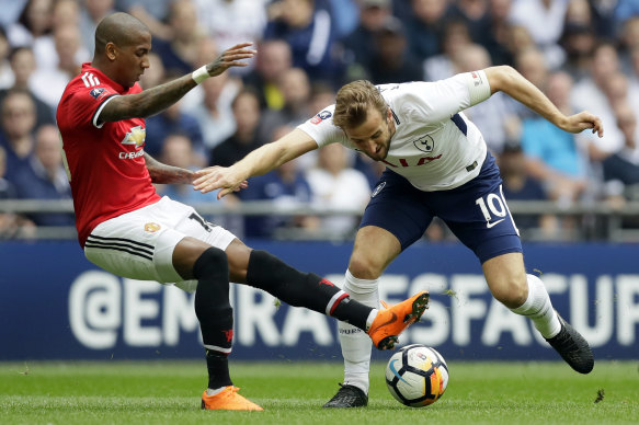 Manchester United's Ashley Young attempts to dispossess Harry Kane.