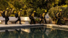 A fire crew in the Pacific Palisades as they move on to their next assignment. The fire has caused significant damage and will push up the cost of insurance policies around the world.