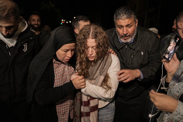 Palestinian activist Ahed Tamimi, center, is supported by her mother after she was released from prison by Israel, in the West Bank town of Ramallah.