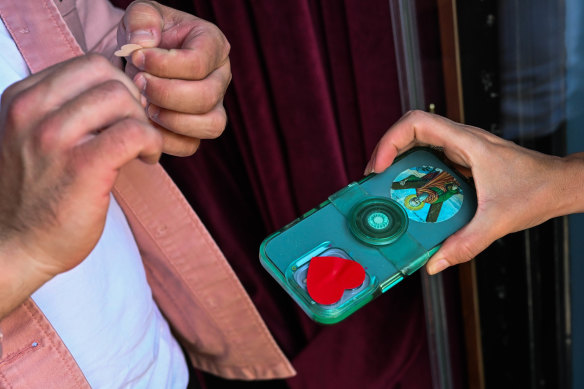 Heart-shaped stickers are placed on customers’ mobile phone cameras at the door.