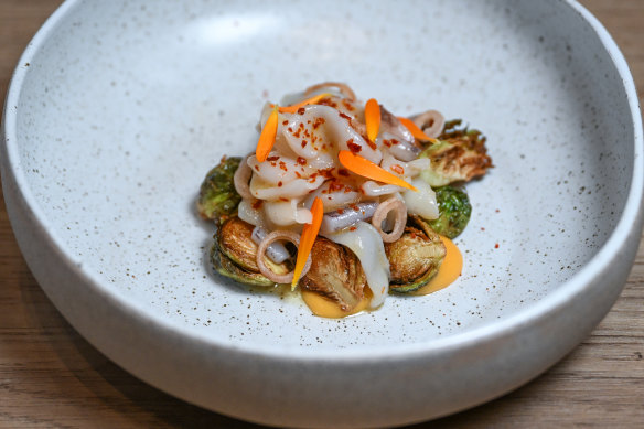 Butter-poached calamari is plated with slightly caramelised Brussels sprouts and a citrusy emulsion.
