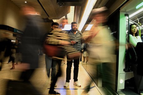 Commuters board a metro train at Victoria Cross station in North Sydney.