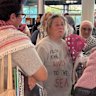 Flotilla activist Helen O’Sullivan (centre) arrives in Brisbane on Monday morning, greeted by about 20 family members and friends including Liam Parry (left), the first person charged under new Queensland hate speech laws.