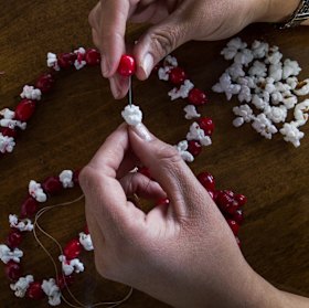 Flossing popcorn onto string can make for an eco-friendly decoration... if you don't eat it first.