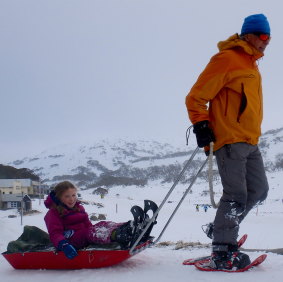 Pete Cocker of K7 Adventures gives Emily a ride back into Perisher on a sled.