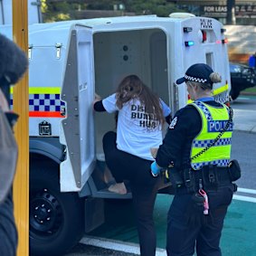 Disrupt Burrup Hub protestor Kristen Morrissey being escorted from Woodside’s headquarters.