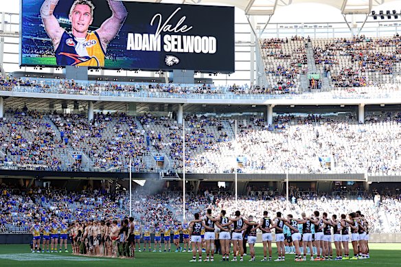 Players and spectators pause in tribute to Adam Selwood in Perth ahead of the game between West Coast and St Kilda.