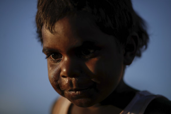A boy waits for performances to start during a community event to celebrate to closure of the Uluru.