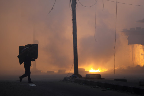 A Palestinian man carries his belongings while fleeing the Naser neighbourhood following an Israeli airstrike on Gaza City this week.