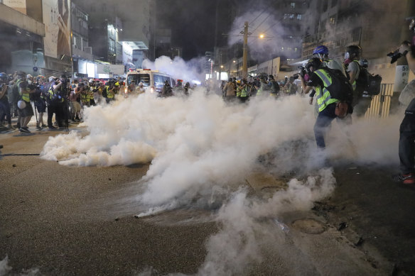 Tear gas fills the street as protesters battle police on the streets of Hong Kong on Saturday.
