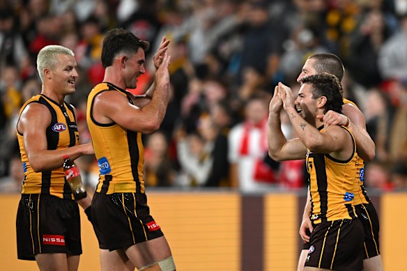 The Coke bottle passes by the waist of Hawthorn’s Jack Ginnivan (left).