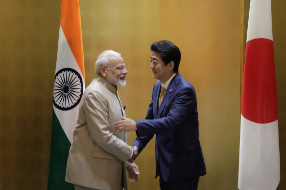 India’s Prime Minister Narendra Modi shakes hands with Japan’s former leader Shinzo Abe in 2019.