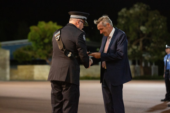Jim Migro being presented his 50-year service medal from former police commissioner Chris Dawson in 2018.