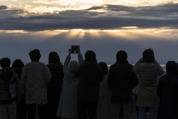 People watch the sun rise on January 1 from Tokyo's Shibuya Sky observation deck.