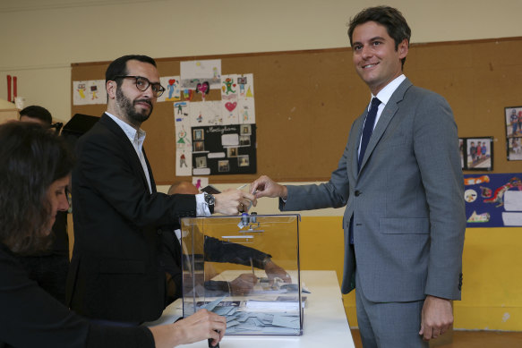 French Prime Minister Gabriel Attal (right) votes for the second round of legislative elections, in Vanves, outside Paris.