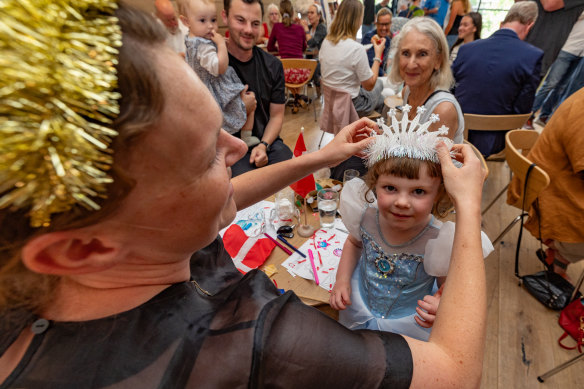 Clara Kynne Schmidt helps three-year-old Ella with a crown at the King’s Ascension Day event in Melbourne on Sunday.