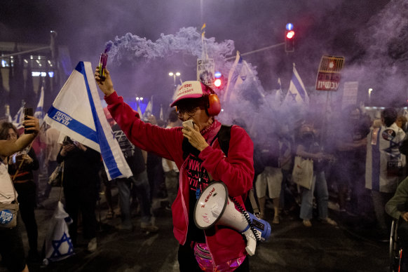 A protester holds a smoke torch during a demonstration calling for the release of hostages held in the Gaza Strip and against Israeli Prime Minister Benjamin Netanyahu