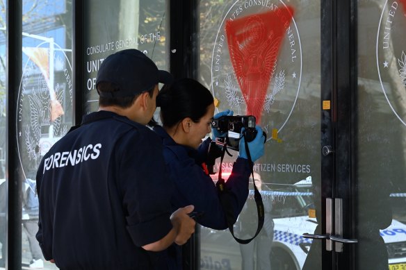 Forensic police examine the graffiti.