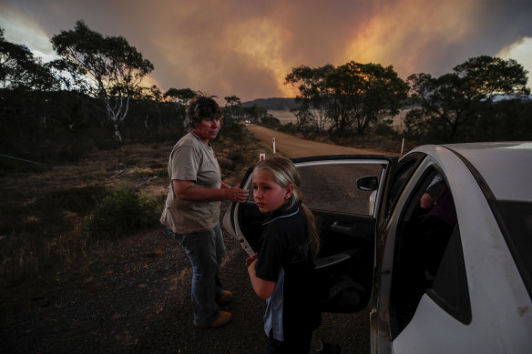 Ten-year-old Kasey Butcher, right, near the North Black Range bushfire on Friday.