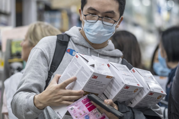 A customer inspects respirators at a pharmacy in the Central district of Hong Kong.
