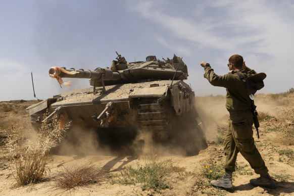 An Israeli soldier directs a tank near the border with the southern part of the Gaza Strip.