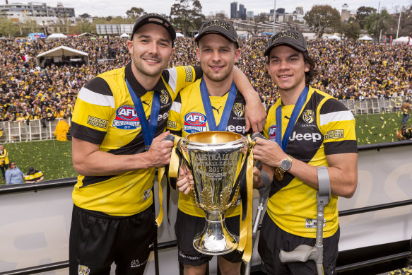 Shaun Grigg, Butler and Daniel Rioli hold the 2017 premiership cup.