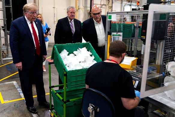 President Donald Trump watches masks being made as he participates in a tour of a Honeywell International plant.