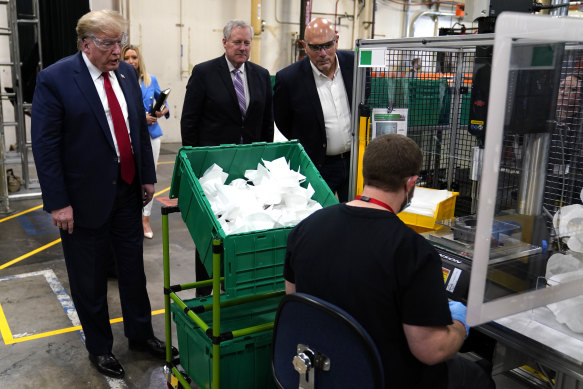 President Donald Trump watches masks being made as he participates in a tour of a Honeywell International plant.