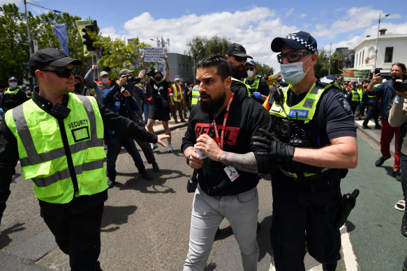 Yemini is moved on by police during a counter-protest against anti-vaxxers, the far-right and fascism in Melbourne in 2021.