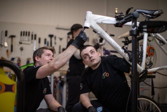 Kieran  McMahon and trainee Daniel Coats working to repair a bike.