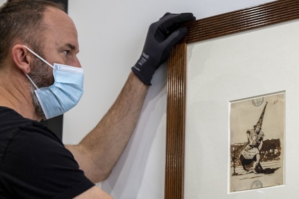 A Goya drawing being hung at the NGV.