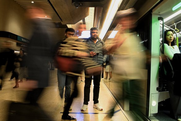 Commuters board a metro train at Victoria Cross station in North Sydney.