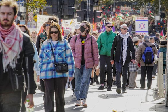 Pro-Palestine protesters march through Melbourne on Sunday. The sign under investigation is shown in the distance.