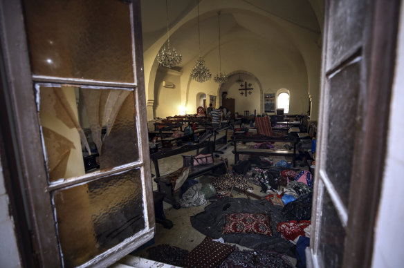 Palestinians inspect the damage in a church people were using as a shelter, at Al Ahli hospital, in Gaza City, Wednesday, October 18, 2023.
