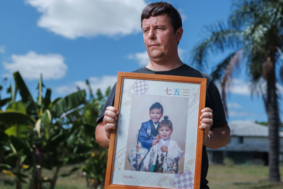 David Fleming holds a picture of his abducted children at his rural property outside of Brisbane.