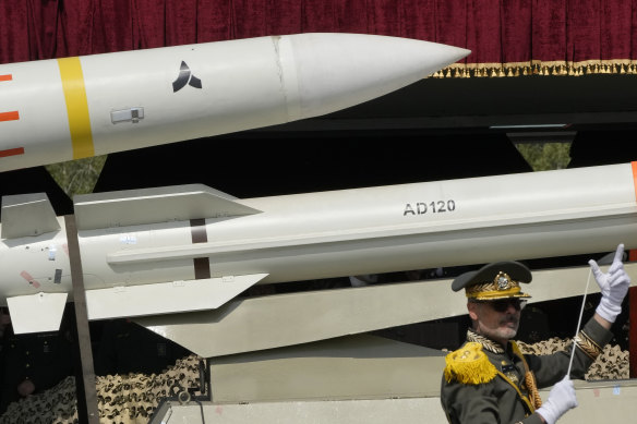 Missiles are carried on a truck as an Iranian army band leader conducts the music band during Army Day parade at a military base in northern Tehran, Iran this month. 