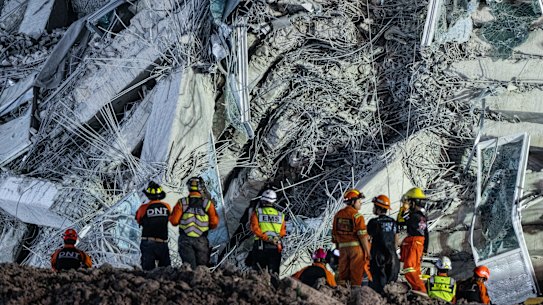 Rescue workers are seen working at the collapsed construction building.