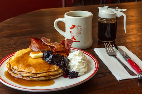 Pancake stack with whipped cream and bacon.