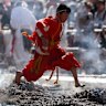 A buddhist monk jump over burning wood sticks during annual “Hiwatari Matsuri” Fire walking festival at Takaosan Yakuoin Temple on March 08, 2026 in Tokyo, Japan. Led by mountain ascetics chanting esoteric prayers, barefoot worshippers file across the smoking embers to seek protection, long life and relief from misfortune.