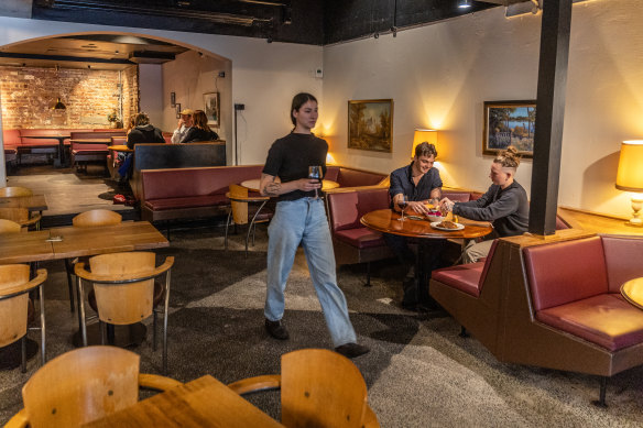 The dining room occupies the former live music space, refitted in wood tones, with big semicircular booths.