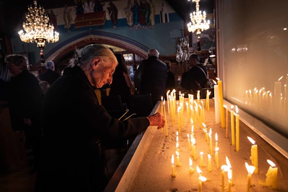 Effie places a candle in mourning for Paul at St Eleftherios Orthodox Church in Brunswick.