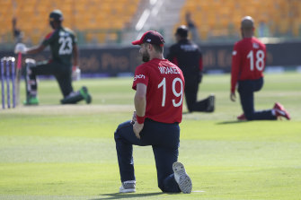 England’s Chris Woakes along with teammates and the Bangladesh side take a knee before their T20 World Cup clash in Abu Dhabi.