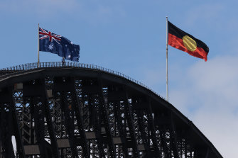 The Australian and Aboriginal flags fly side-by-side on the Harbour Bridge on Australia Day.