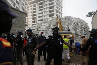 Rescue workers are seen at the site of a collapsed 21-storey apartment building under construction in Lagos, Nigeria, on Tuesday AEDT.