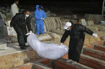 Caretakers bury a migrant in a cemetery of Sfax, eastern Tunisia, following a migrant shipwreck off Tunisia's coast. 