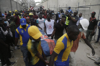 Rescue workers carry a body retrieved from the site of a collapsed apartment block in Lagos, Nigeria.