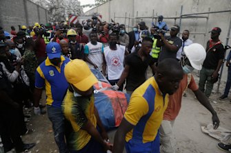 Rescue workers carry a body retrieved from the site of a collapsed apartment block in Lagos, Nigeria.