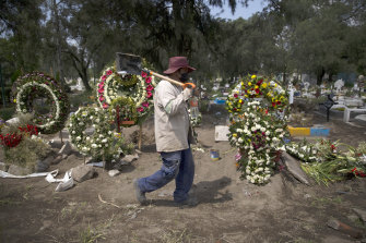 A grave digger walks in the COVID-19 section of the cemetery of San Lorenzo Tezonco Iztapalapa on the outskirts of Mexico City.